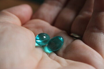 Blue capsules in open hand 