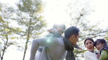 young asian family with two kids having fun outdoors in park