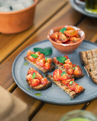 Tomato bruschetta served on plate with extra cherry tomatoes and toasted bread
