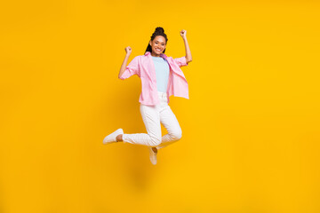 Fototapeta na wymiar Photo of cheerful lady jump rejoice achievement luck wear striped shirt isolated yellow color background