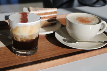 Cappuccino and espresso with carrot cake on serving tray