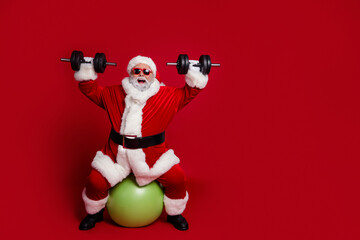 Full length body size view of attractive cheerful Santa working out aerobics isolated over bright...