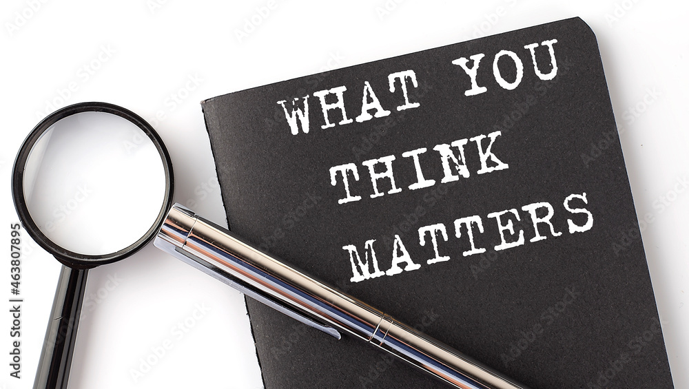Poster what you think matters - business concept, magnifier with white text message on the black notebook
