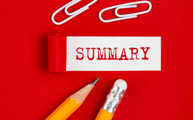 SUMMARY written on torn red paper with pencils and clips, business concept