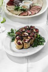 Fried eggplant slices stuffed with soft cheese and pomegranate on the table