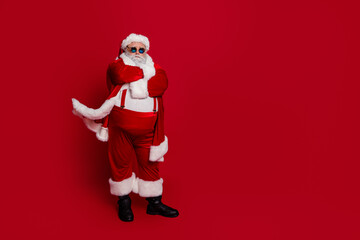 Photo of self-assured pensioner man crossed hands prepare x-mas event wear santa hat costume isolated red color background