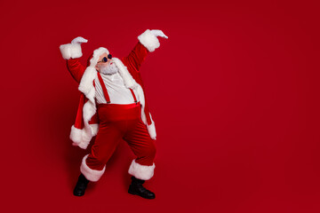 Fototapeta na wymiar Photo of carefree pensioner man dance have x-mas winter fun wear santa hat costume isolated red color background