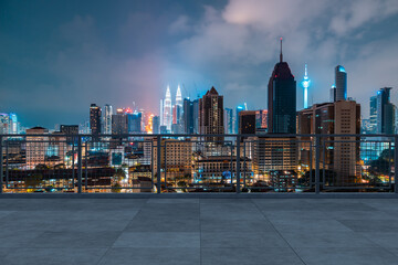 Panoramic Kuala Lumpur skyline view, concrete observatory deck on rooftop, night. Asian corporate...