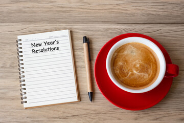 New Year Resolution with notebook, black coffee cup and pen on wood table. Xmas, Happy New Year, Goals, To do list, Strategy and Plan concept