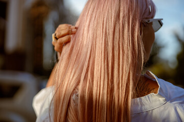 Young woman touching her hair on the street