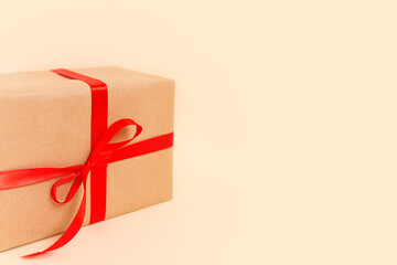 Christmas gift box with red bow on beige background. Holiday concept, New year presents.