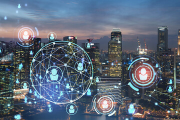 Glowing Social media icons on night panoramic city view of Singapore, Asia. The concept of networking and establishing new connections between people in businesses. Double exposure.