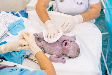 Baby being born via Caesarean Section coming out baby minutes after the birth. Unrecognizable...