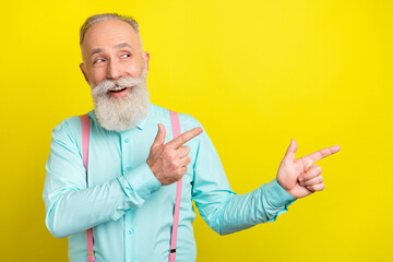 Photo of cunning elder man point look empty space wear blue shirt isolated on vivid yellow color...