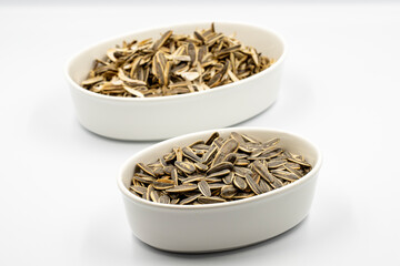 Sunflower seeds and sunflower seed litter on a white background