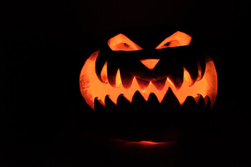 Halloween Head Jack Pumpkin with Scary Smile and Burning Candle Inside for Party Night on Black Background