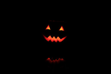 Halloween Head Jack Pumpkin with Scary Smile and Burning Candle Inside for Party Night on Black Background