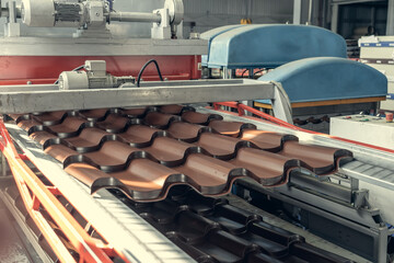 Production line of metal tile for roof. Conveyor belt at metalworking manufacturing plant.