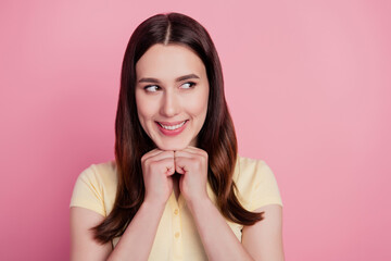 Photo of cheerful positive woman look empty space hands chin think on pink background