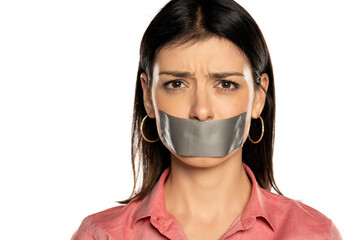 Portrait of a woman with a tape over mouth, isolated on white.