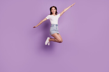 Portrait of funny nice attractive lady fooling around jump on purple background