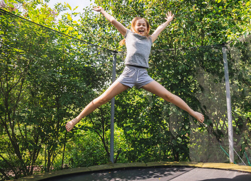 Girl enjoy bouncing on a trampoline outdoors