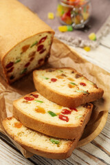 Delicious cake with candied fruits on white wooden table, closeup