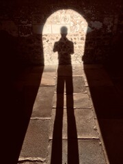 silhouette of a person in a doorway with old flagstones