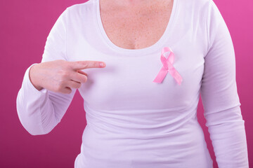 Midsection of caucasian woman in white tshirt with pink ribbon gesturing