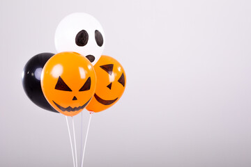 Orange, black and white halloween balloons over white background