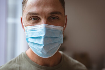 Close up view of caucasian man wearing face mask at home