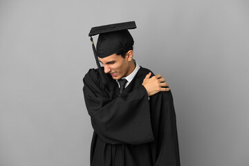 Young Argentinian university graduate isolated on grey background suffering from pain in shoulder for having made an effort