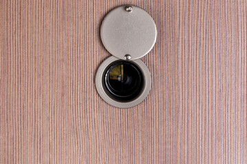 peep hole lens on wooden texture.