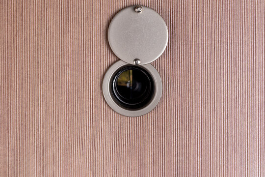 peep hole lens on wooden texture.