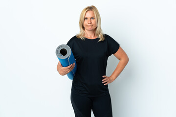 Middle age woman going to yoga classes while holding a mat isolated on white background with sad...