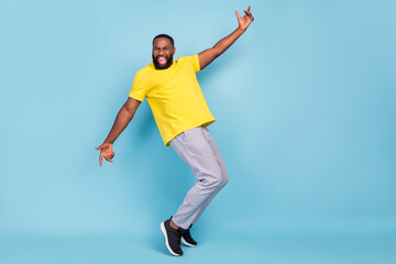 Fototapeta premium Photo of excited funny dark skin guy dressed yellow t-shirt dancing smiling isolated blue color background