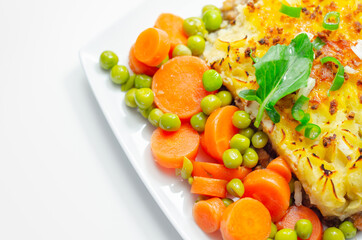 Shepherd's pie, tender minced lamb with garden veg in a hearty gravy beneath butter mash with carrots and green peas