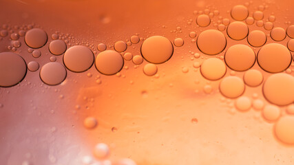 Water in oil in abstract style on yellow background. Orange liquid splash. Golden yellow bubble oil...