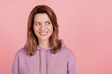 Photo of mature attractive woman happy positive smile guess look empty space mindede idea isolated over pink color background