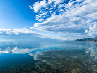 clouds reflection on the lake surface, natural colors, blue background