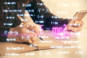 Double exposure of formulas sketch hologram and woman holding and using a mobile device. Education concept.
