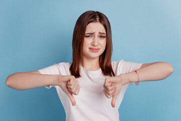 Photo of young girl show thumbs-down bad dislike moody ad quality decline isolated over blue color...