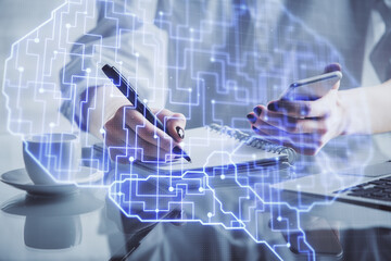 Double exposure of brain sketch hologram and woman holding and using a mobile device.