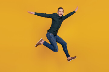 Fototapeta na wymiar Full size profile side photo of young excited man have fun jumper fly wings plane isolated over yellow color background