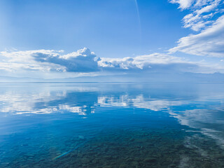 clouds reflection on the lake surface, natural colors, blue background