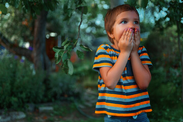 A child with a frightened face stands in the park