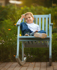 the child sits on a chair in the summer on the street