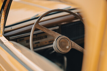 Oldtimer car dashboard. Retro car interior. Old steering wheel detail.