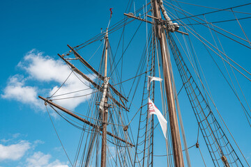 Fototapeta premium Mast of a sail ship with the danish flag, in the harbor of Copenhagen