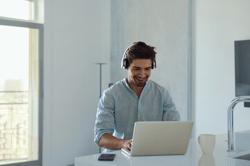 Fototapeta premium Man working remotely with laptop computer at home
